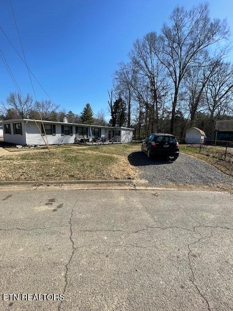 view of front of house with driveway and a front lawn