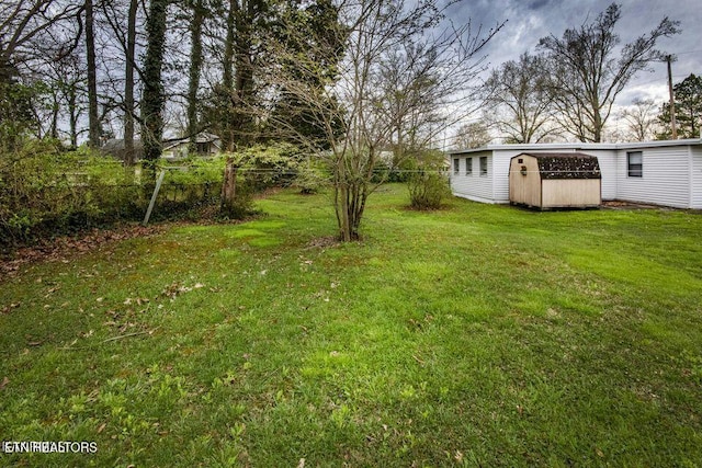 view of yard with a storage unit, an outbuilding, and fence