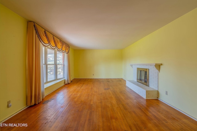 unfurnished living room featuring a fireplace and hardwood / wood-style floors