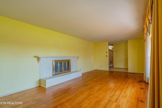 unfurnished living room featuring wood finished floors and a fireplace