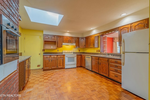 kitchen with under cabinet range hood, appliances with stainless steel finishes, brown cabinetry, and a sink