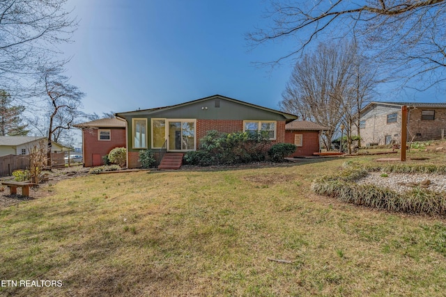 view of front of house featuring a front lawn and brick siding