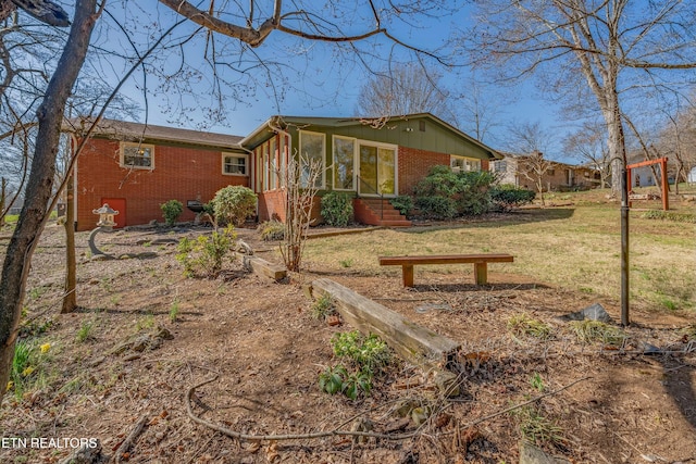 exterior space with brick siding and a lawn