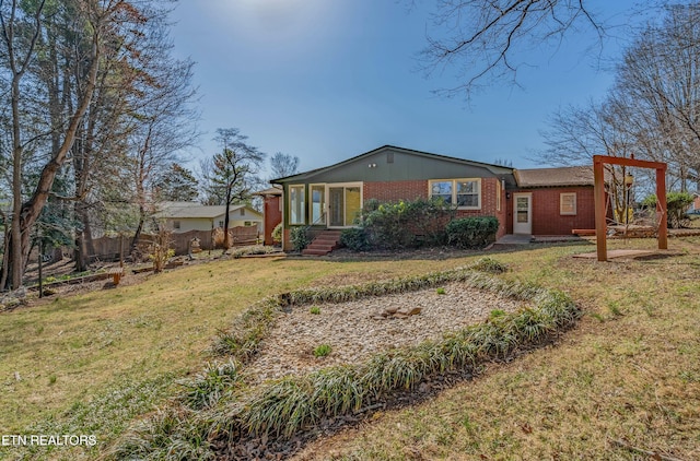 view of front of property featuring brick siding and a front yard