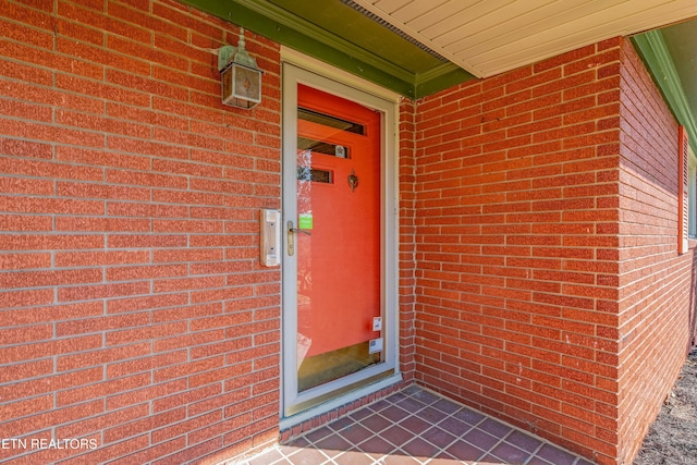 view of exterior entry with brick siding