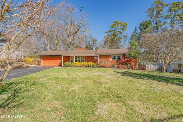 ranch-style home featuring a front yard, fence, a garage, aphalt driveway, and brick siding