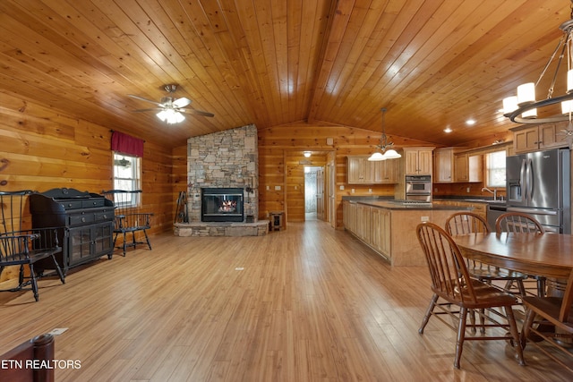 interior space with lofted ceiling, a fireplace, wood ceiling, wood walls, and light wood-type flooring