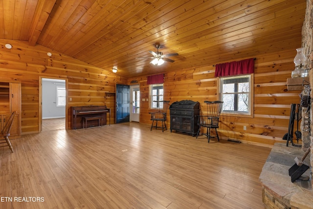 living area with light wood-type flooring, plenty of natural light, and vaulted ceiling