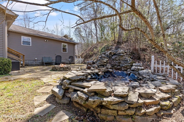 view of yard featuring a patio area, a fire pit, and central AC