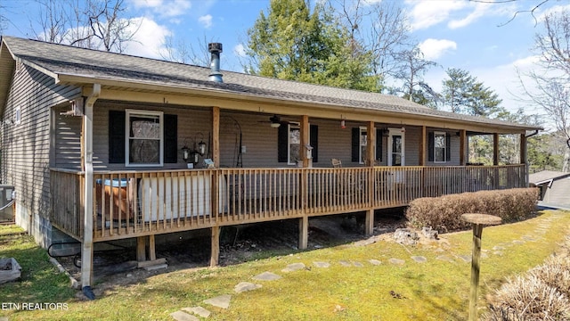 view of front facade with a front yard, central AC unit, and roof with shingles