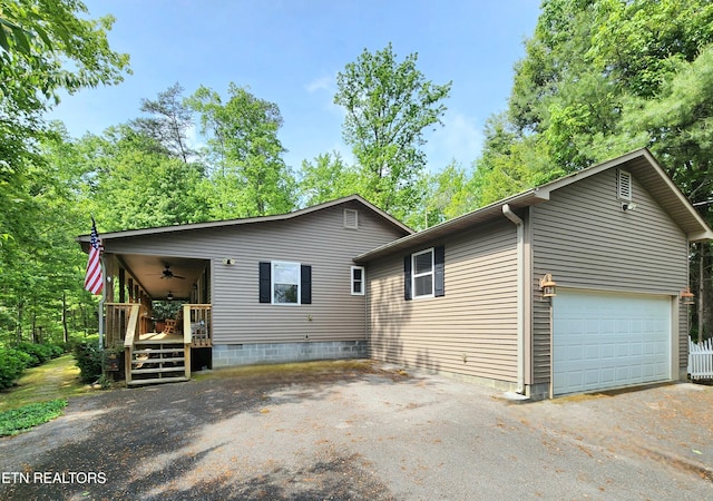 view of front of house featuring ceiling fan, a garage, and driveway