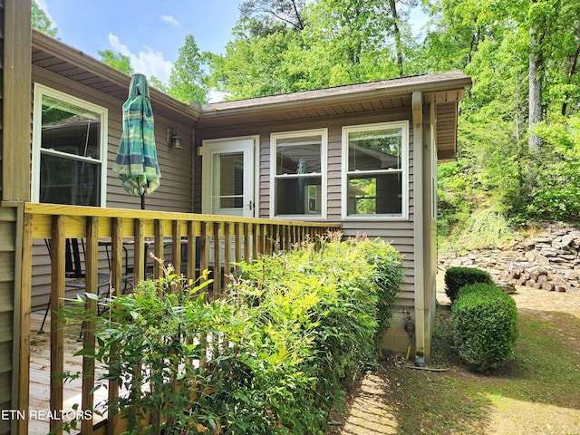 view of property exterior with a wooden deck