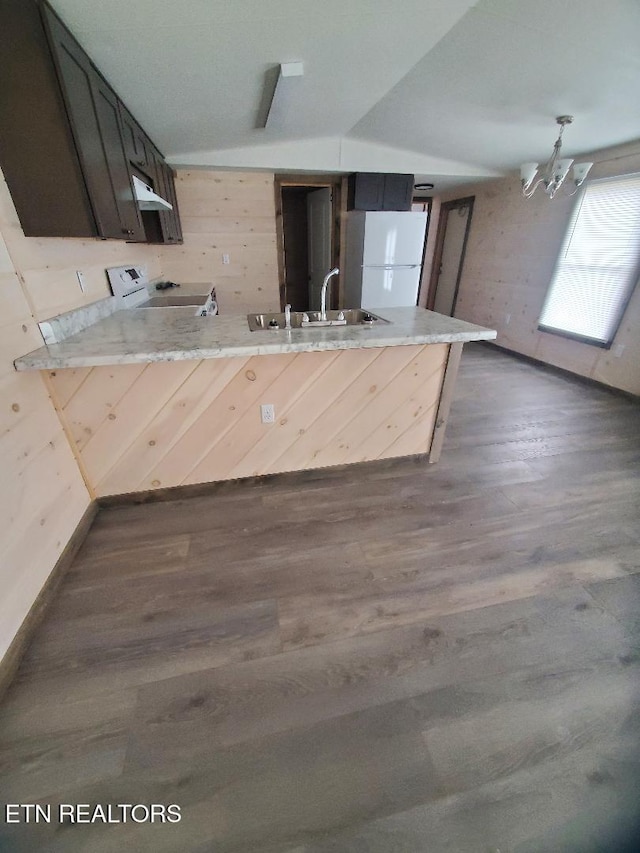 kitchen with electric stove, a sink, freestanding refrigerator, a peninsula, and light countertops