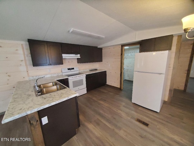 kitchen with white appliances, dark wood finished floors, lofted ceiling, a sink, and under cabinet range hood