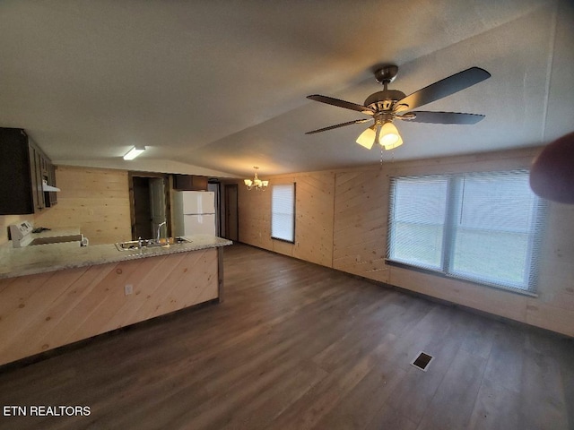 kitchen with dark wood-style floors, a peninsula, freestanding refrigerator, a sink, and range