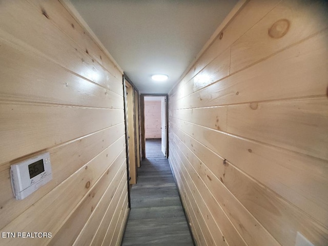 hallway featuring dark wood-style floors and wood walls