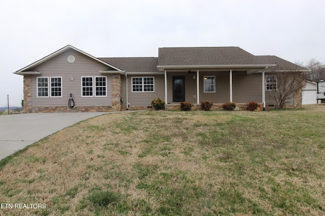 ranch-style house featuring covered porch, a shingled roof, and a front lawn