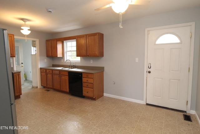 kitchen featuring visible vents, a ceiling fan, a sink, black dishwasher, and freestanding refrigerator