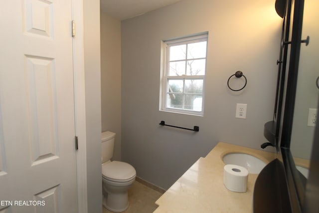 bathroom with vanity, toilet, and baseboards