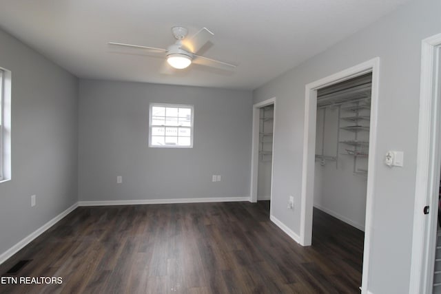 unfurnished bedroom featuring visible vents, dark wood-style floors, and baseboards