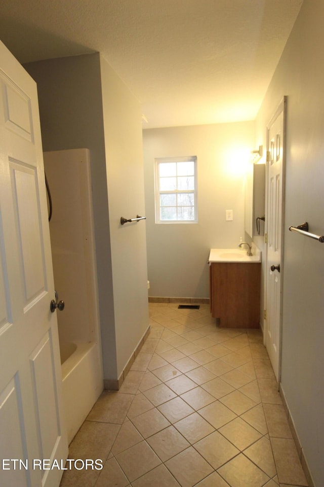 bathroom with tile patterned floors, toilet, tub / shower combination, baseboards, and vanity