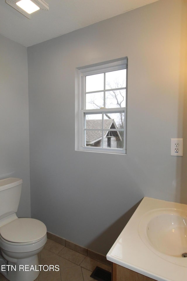 bathroom with vanity, baseboards, visible vents, tile patterned floors, and toilet