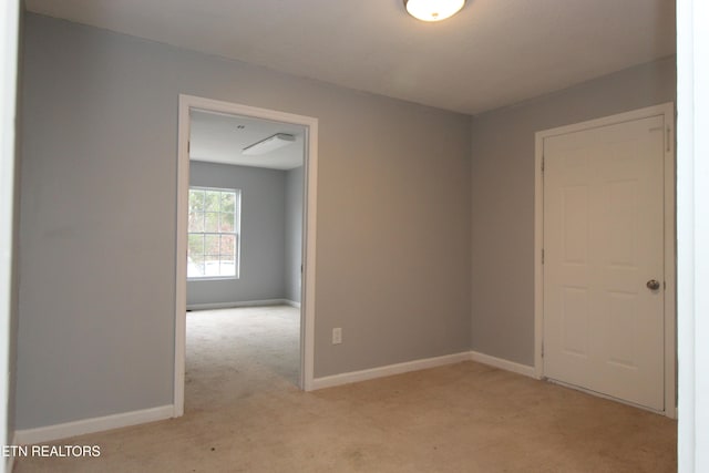 unfurnished room featuring baseboards and light carpet