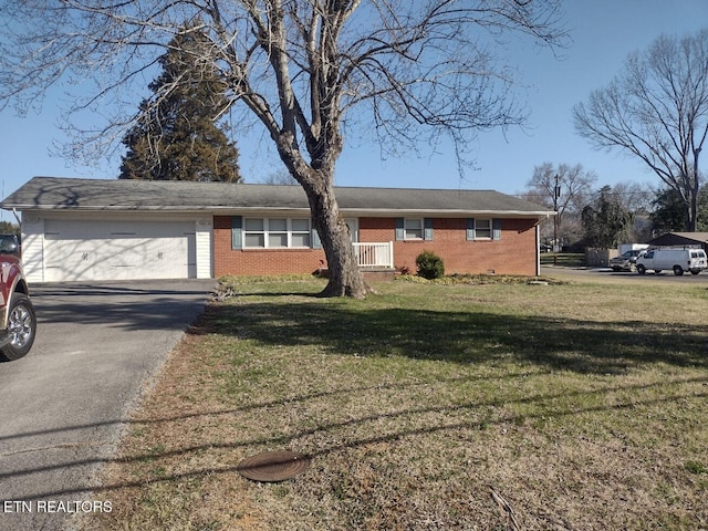 view of front facade with a front yard, brick siding, a garage, and driveway