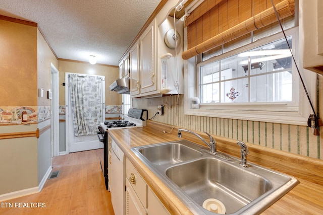 kitchen with visible vents, light wood finished floors, a sink, a textured ceiling, and range with gas cooktop