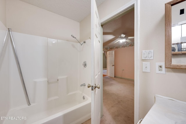 bathroom featuring ceiling fan, shower / bath combination, and a textured ceiling