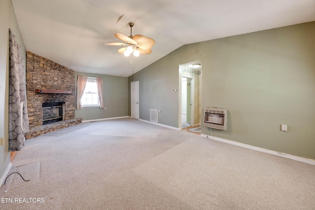 unfurnished living room featuring visible vents, vaulted ceiling, carpet floors, a fireplace, and heating unit