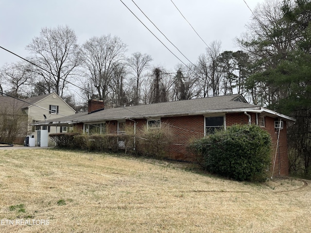 exterior space with a front lawn, brick siding, and a chimney