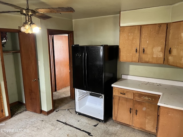 kitchen featuring light floors, light countertops, freestanding refrigerator, and a ceiling fan