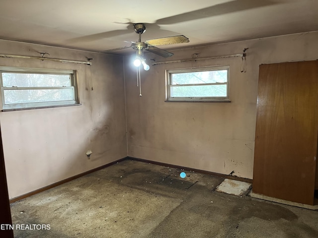 empty room with baseboards, a healthy amount of sunlight, and ceiling fan