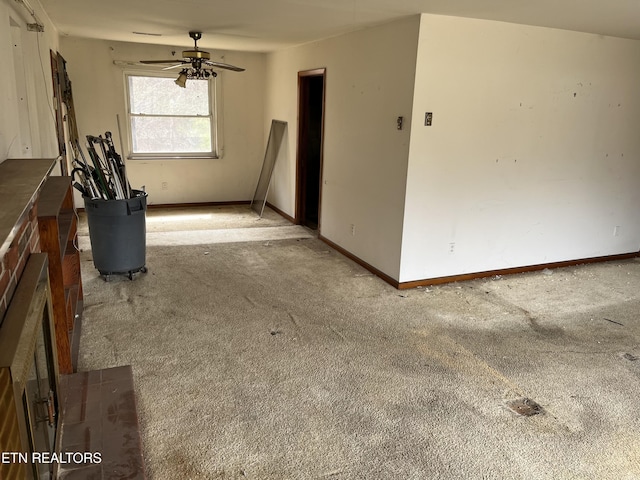 unfurnished living room with carpet flooring, a ceiling fan, and baseboards