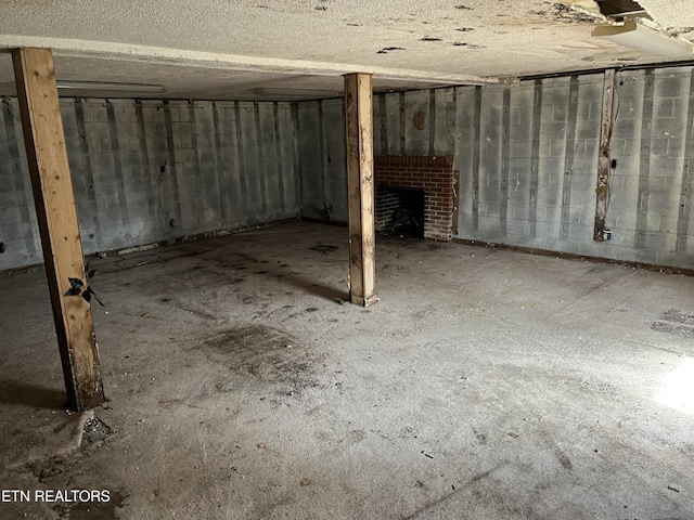 unfinished basement featuring a fireplace