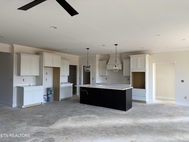 kitchen featuring white cabinetry, crown molding, baseboards, and a kitchen island