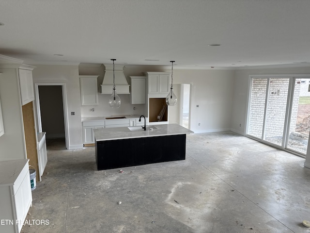 kitchen featuring a center island with sink, concrete flooring, baseboards, and a sink