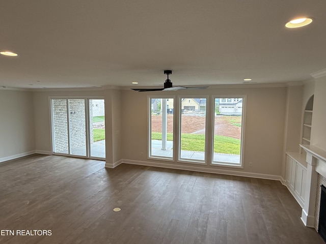 unfurnished living room featuring baseboards, recessed lighting, ornamental molding, and dark wood-style flooring