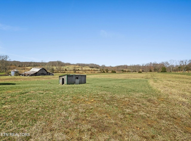 view of yard featuring an outbuilding and a rural view