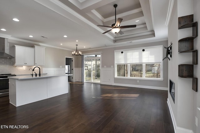 kitchen featuring open floor plan, light countertops, electric stove, wall chimney exhaust hood, and dark wood-style flooring