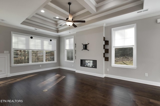 unfurnished living room featuring plenty of natural light, a glass covered fireplace, and dark wood-style flooring