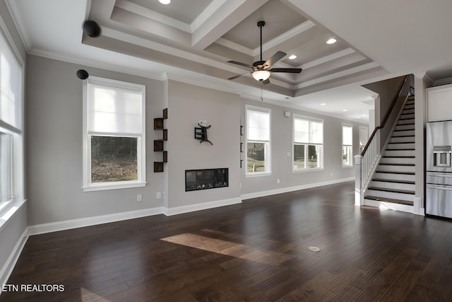 unfurnished living room with crown molding, baseboards, stairs, wood finished floors, and a glass covered fireplace