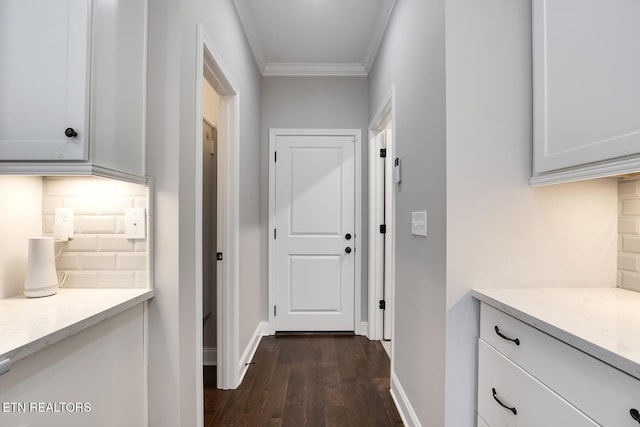 corridor featuring baseboards, dark wood-style floors, and crown molding