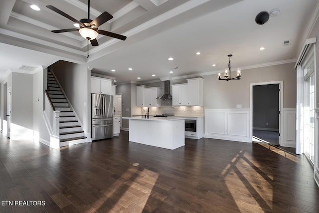 kitchen featuring dark wood finished floors, light countertops, ornamental molding, stainless steel appliances, and wall chimney exhaust hood