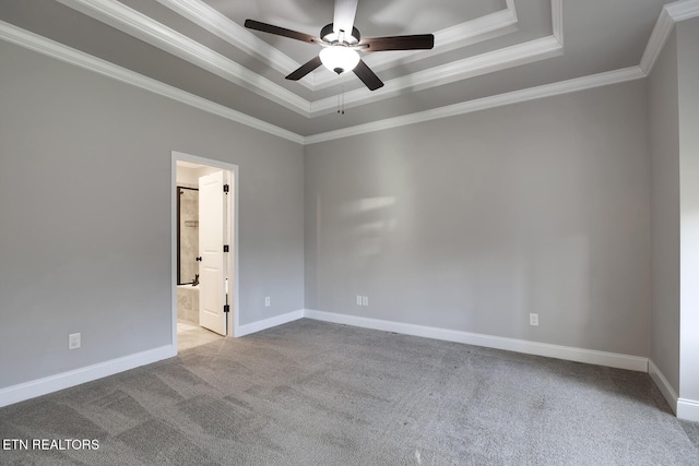 carpeted spare room featuring baseboards, a raised ceiling, ornamental molding, and a ceiling fan