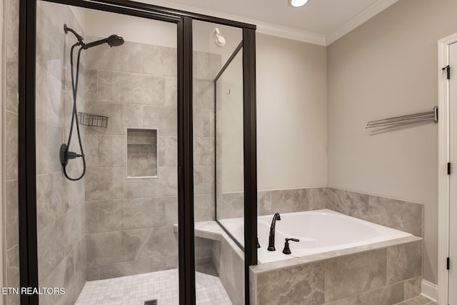 bathroom with a shower stall, a garden tub, and ornamental molding