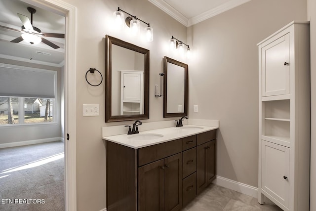 full bath featuring double vanity, ornamental molding, baseboards, and a sink