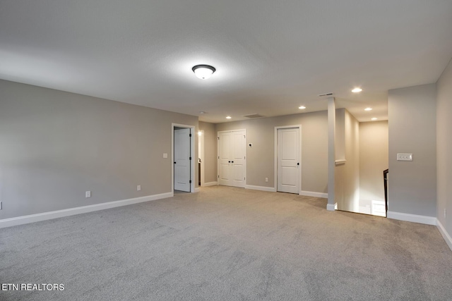 unfurnished room with light colored carpet, recessed lighting, and baseboards