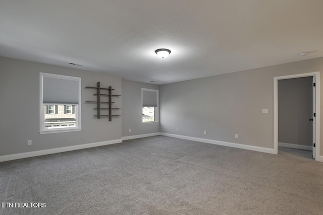 empty room with baseboards and carpet